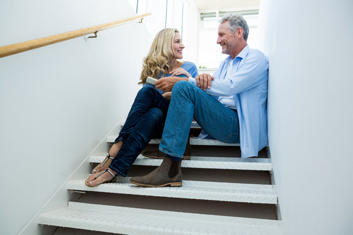 Pareja sentada en una escalera, planificando su futuro hogar